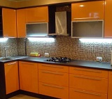 Оранжевая кухня под заказ с пленочными фасадами МДФ и темной столешницей